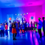 Vista de una fiesta fluor vibrante con invitados bailando bajo luces neón y decoraciones brillantes.